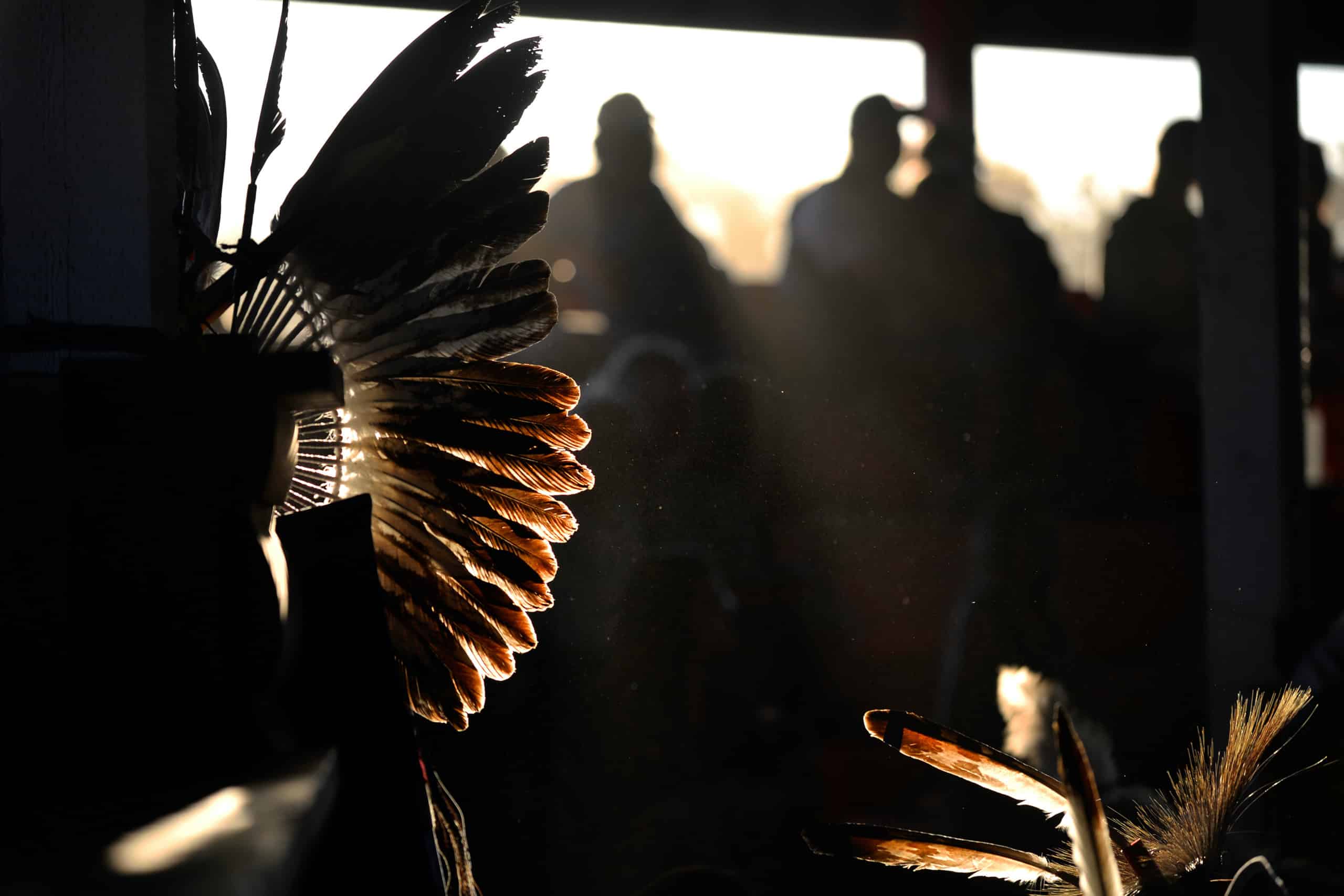 The evening sun hits a headdress at a powwow, June 2016. File photo by Philip McLachlan