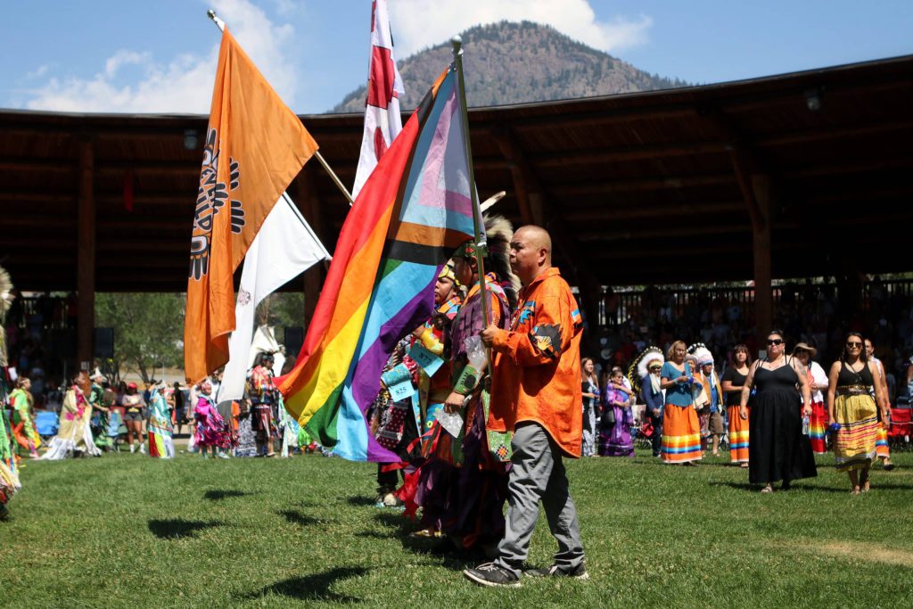 Kukpi7 (Chief) Doug Thomas of Splatsin First Nation carries a Pride flag during the grand entry of the second day of the 41st Kamloopa Powwow in Tk’emlúps (Kamloops) in Secwépemc homelands on July 30. Photo by Aaron Hemens