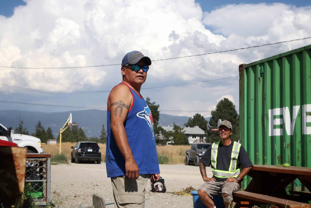 Indigenous guardians, Clint Gabriel and Dean Schreiber, stand in a parking lot outside of the Penticton Indian Band’s Natural Resources office in syilx homelands on a sunny afternoon.