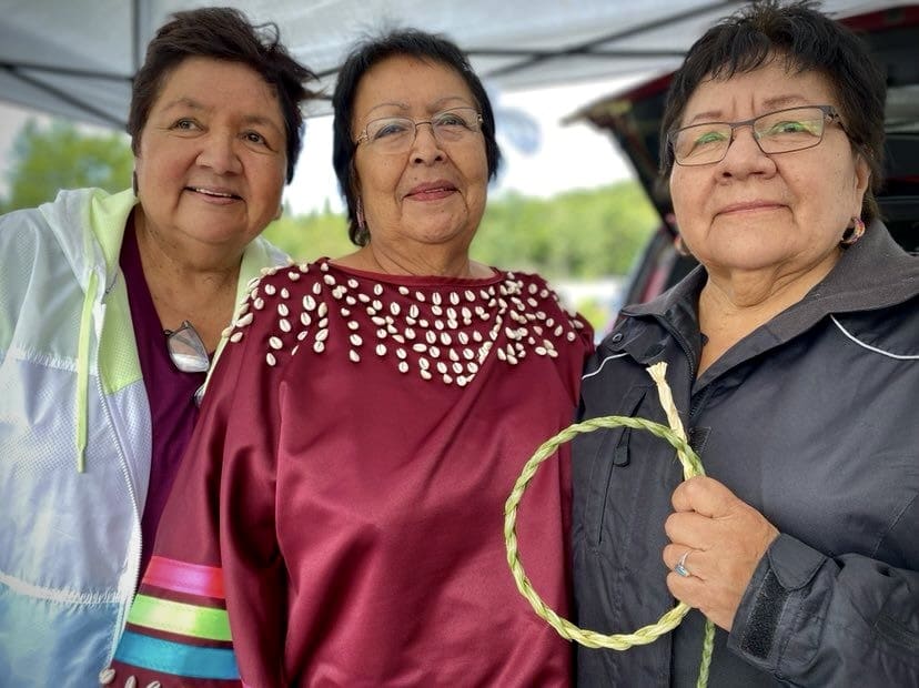 Three sisters from M'chigeeng Nation, holding their braided sweetgrass and talking about wellness. 