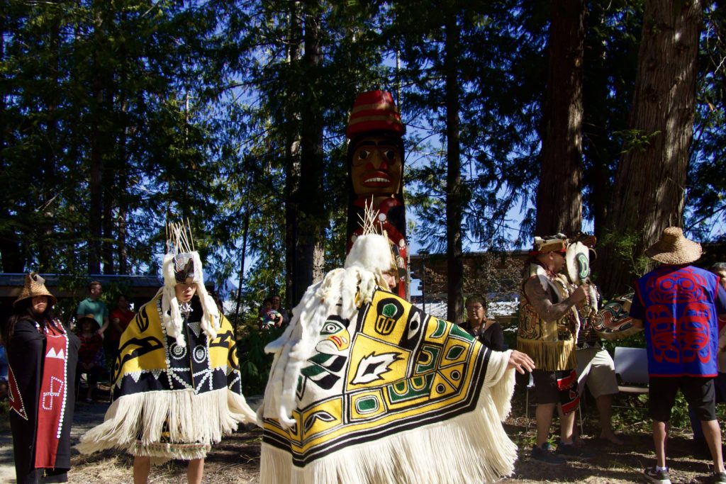 Carver dances in regalia with his son while family drums and sings
