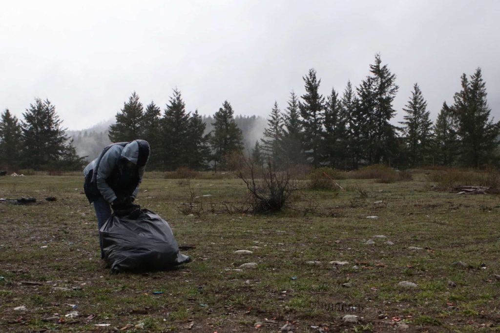 A community member cleans up garbage during a cleanup of an area of the “Peachland” watershed in syilx homelands on April 30. Photo by Aaron Hemens