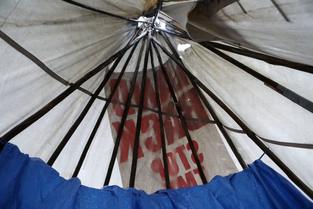 An inside view of a tipi that was assembled along the Trans Mountain Pipeline Expansion (TMX) project’s route in “Burnaby” on Jan. 21. The message hanging on the tipi’s exterior reads “Land Back, Stop TMX.” Photo by Aaron Hemens