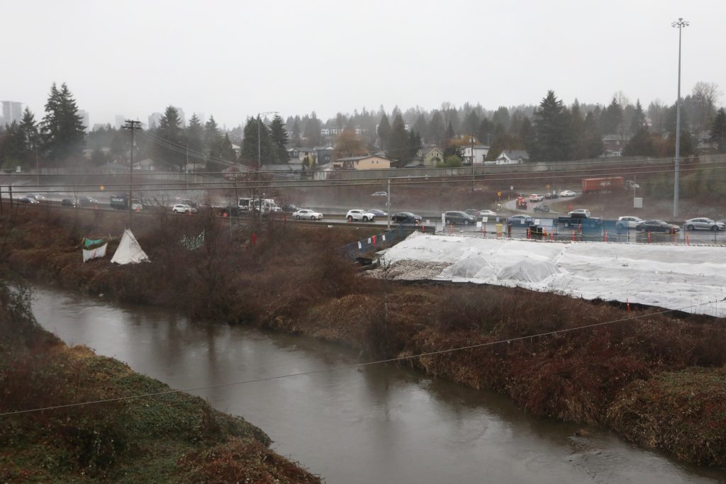 Looking westbound on the Trans Canada Highway in “Burnaby” on Jan. 21. Adjacent to the eastbound highway is the Brunette River and the construction of the Trans Mountain Pipeline Expansion (TMX), with a tipi in its path to disrupt the pipeline’s development. Photo by Aaron Hemens