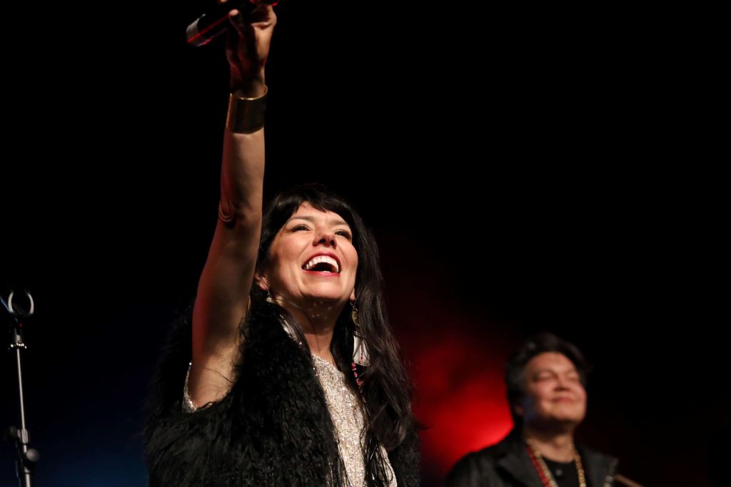 Husband and wife duo ShoShona Kish, left, and Raven Kanatakta of Indigenous musical group Digging Roots perform at the 2023 skəlɣap Movable Feast show in snpintktn (Penticton) in syilx homelands on March 29. Photo by Aaron Hemens