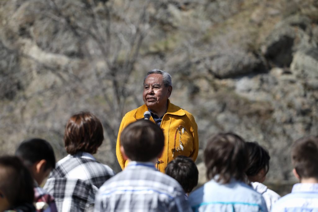 snpinktn (Penticton) Hereditary Chief Adam Eneas speaks in front of Youth during the Osoyoos Indian Band’s celebration on April 14 of a reclaimed one acre of their original reserve land. Photo by Aaron Hemens