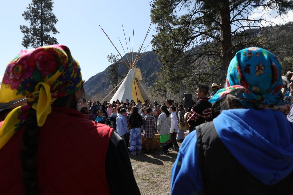 syilx Elders watch as students from Senpaq'cin School play a drum song during the Osoyoos Indian Band’s celebration on April 14 of a reclaimed one acre of original reserve land. Photo by Aaron Hemens
