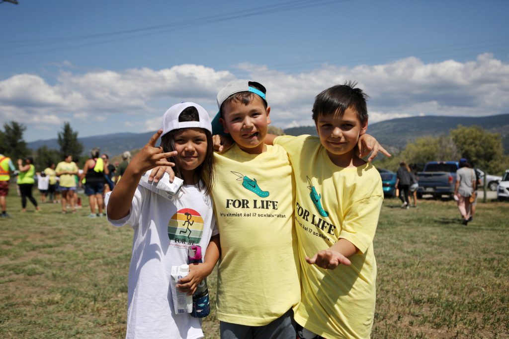 First-time Spirit of Syilx Unity Run participants (from left to right) Mia Haines Wilson, Kruz Kruger and Nyah Jack from Outma Sqilx'w Cultural School on June 1, at the starting point of this year’s run at the Syilx Nation Indian Residential School Monument in snpintktn (Penticton). Photo by Aaron Hemens