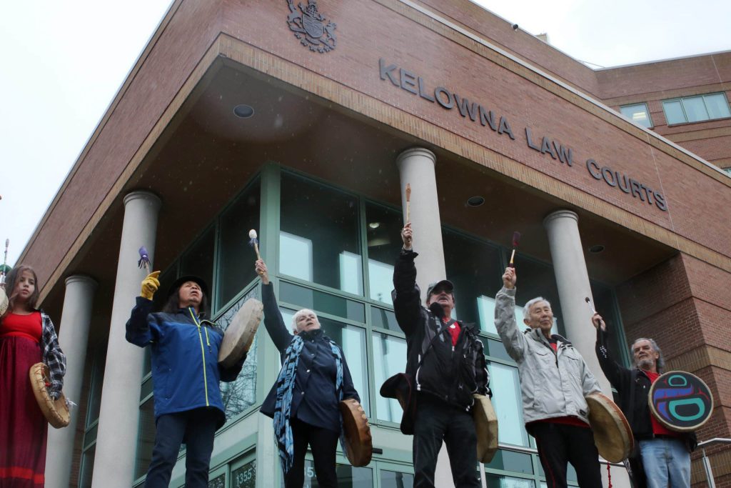 Drummers raise their sticks in the air outside of Kelowna Law Courts on May 5, 2022, after marching to the building in honour of missing and murdered Indigenous women, girls and Two-Spirit people. Photo by Aaron Hemens