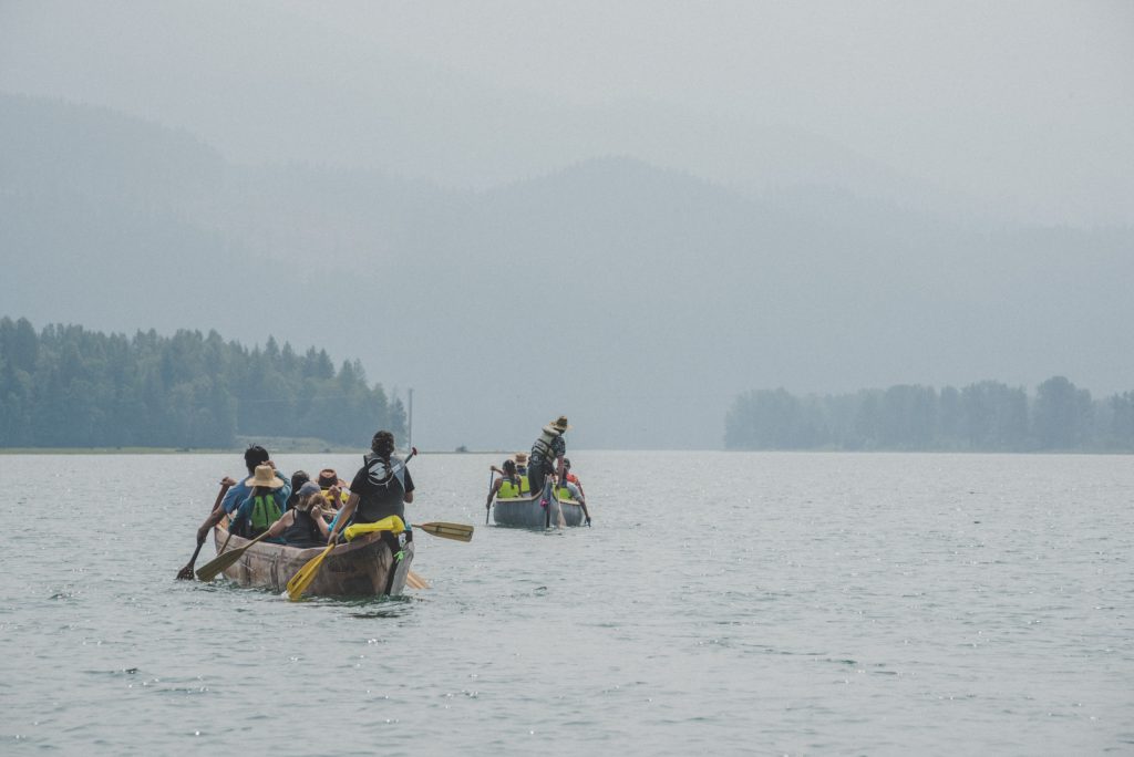 In June 2023, Sinixt and Secwépemc people paddled through the Upper Columba. On the second day of the journey, wildfire smoke shrouded the mountains around sn̓ʕaýckst place of the bull trout (Arrow Lakes). Photo by Mike Graeme