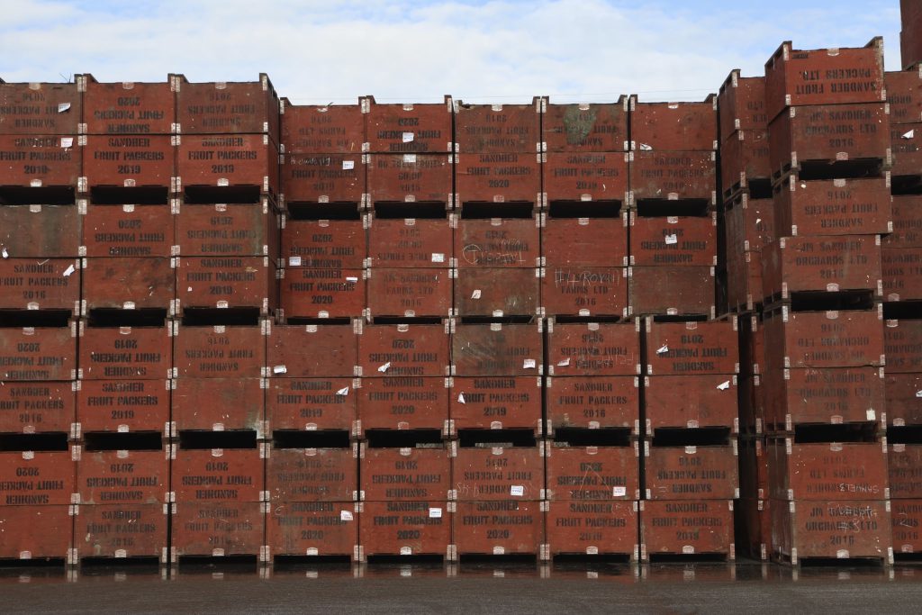 Fruit crates owned by Sandher Fruit Packers sit stacked at its headquarters in Kelowna, British Columbia, on Feb. 8, 2024. The fruit growing company is developing an orchard near a key wildlife corridor that ribbons around the Okanagan Mountain Provincial Park and Kalamalka Lake Provincial Park. Aaron Hemens/IndigiNews via AP