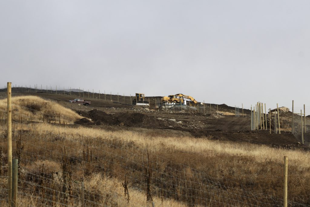 Construction machinery work within a fenced-off cherry orchard expansion site near Kelowna, British Columbia, on Dec. 7, 2023. Experts are concerned that the cherry orchard's expansion is impacting the mobility of animals that use a nearby wildlife corridor in an area under threat from urban sprawl and other development. Aaron Hemens/IndigiNews via AP