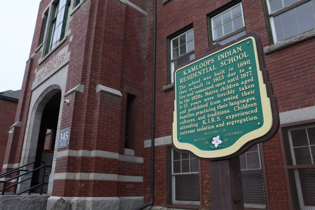 Signage outside the entrance to the former Kamloops Indian Residential School, outlining its history. Photo by Aaron Hemens