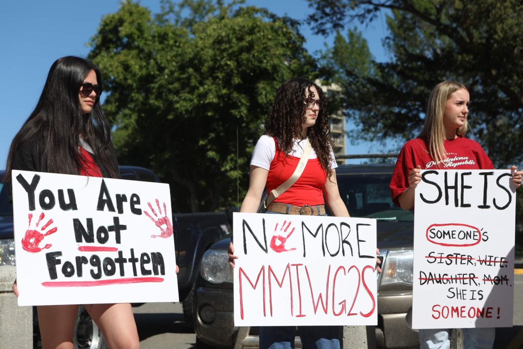 Community members hold up signs honouring missing and murdered women outside of Kamloops Courts in Secwepemcúl'ecw on June 20. Photo by Aaron Hemens