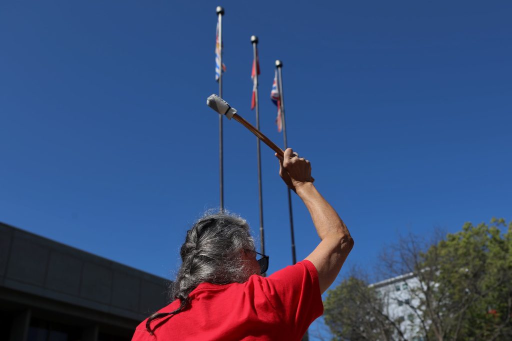 A drummer raises their stick in the air during a rally denouncing violence against women outside of Kamloops Courts in Secwepemcúl'ecw on June 20. Photo by Aaron Hemens