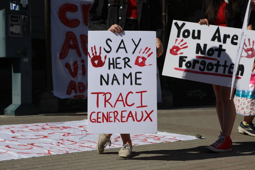 A community member holds up a sign honouring Traci Genereaux outside of Kamloops Courts in Secwepemcúl'ecw on June 20. Photo by Aaron Hemens