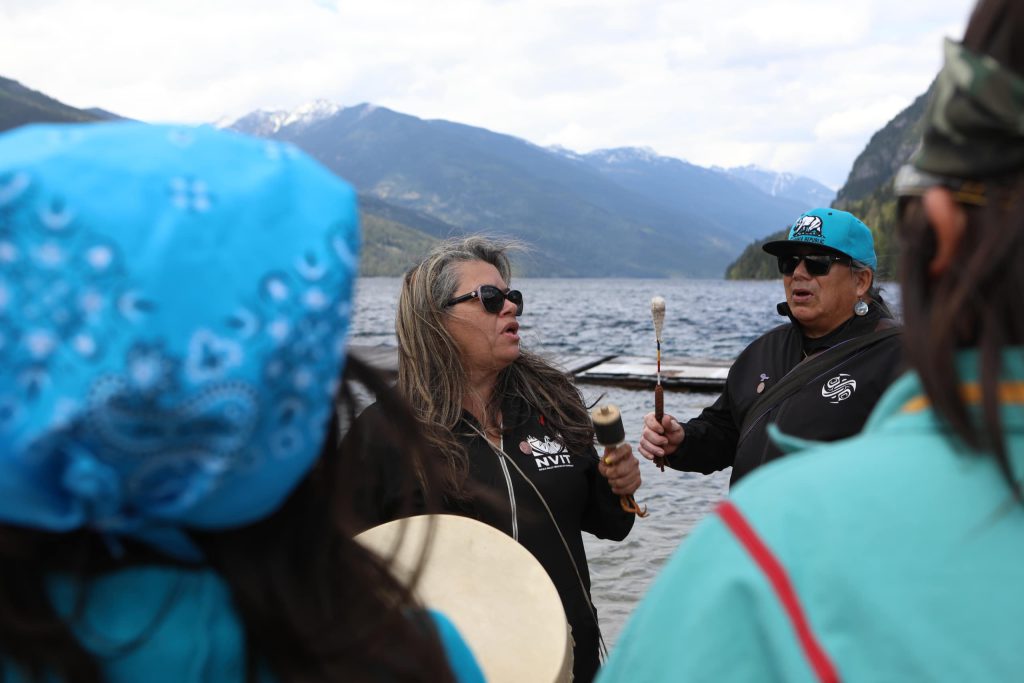 syilx Okanagan singers and drummers are pictured near Slocan Lake in syilx Okanagan territory during a ceremonial release hosted by the Okanagan Nation Alliance on May 13, 2024. Photo by Aaron Hemens