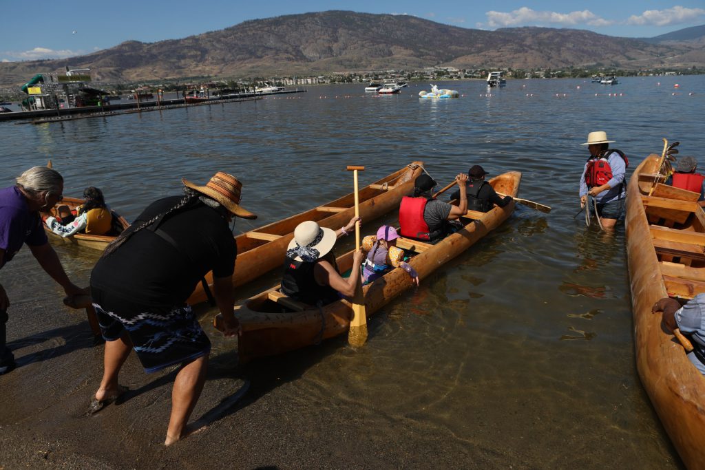 Community members prepare a canoe at nk’mip (Osoyoos Lake) in sw̓iw̓s (Osoyoos) at the launch of the 2024 Sukʷnaqin canoe journey. Photo by Aaron Hemens