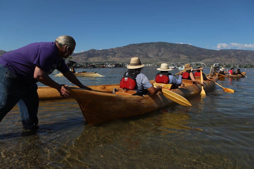 Community members prepare a canoe at nk’mip (Osoyoos Lake) in sw̓iw̓s (Osoyoos) at the launch of the 2024 Sukʷnaqin canoe journey. Photo by Aaron Hemens