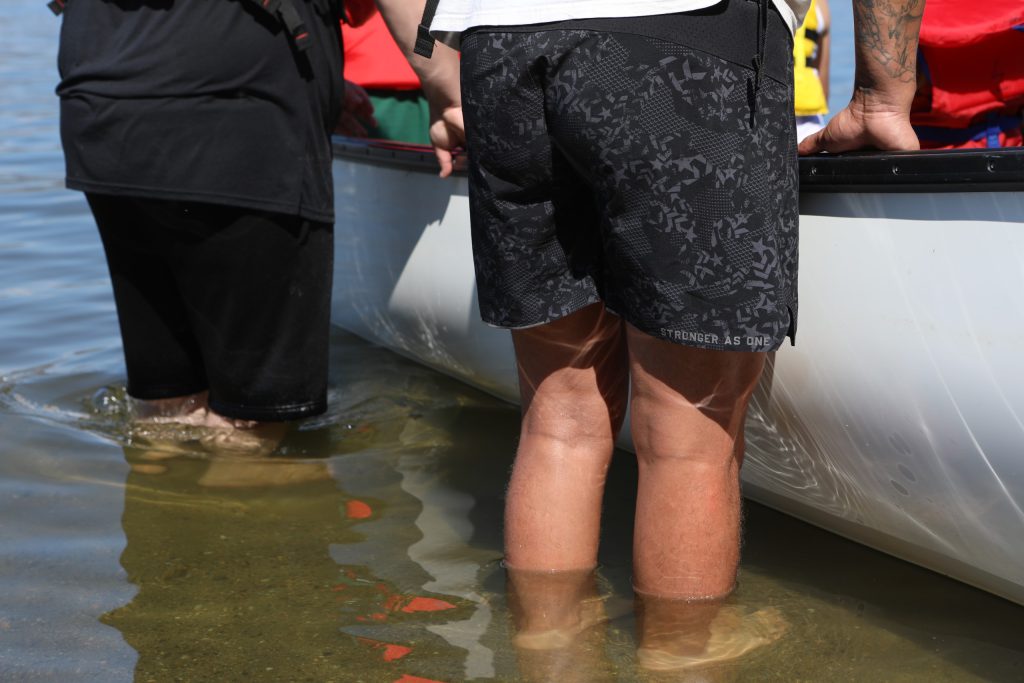 Community members ready a canoe Community members carry a canoe at nk’mip (Osoyoos Lake) in sw̓iw̓s (Osoyoos) at the launch of the 2024 Sukʷnaqin canoe journey. Photo by Aaron Hemens