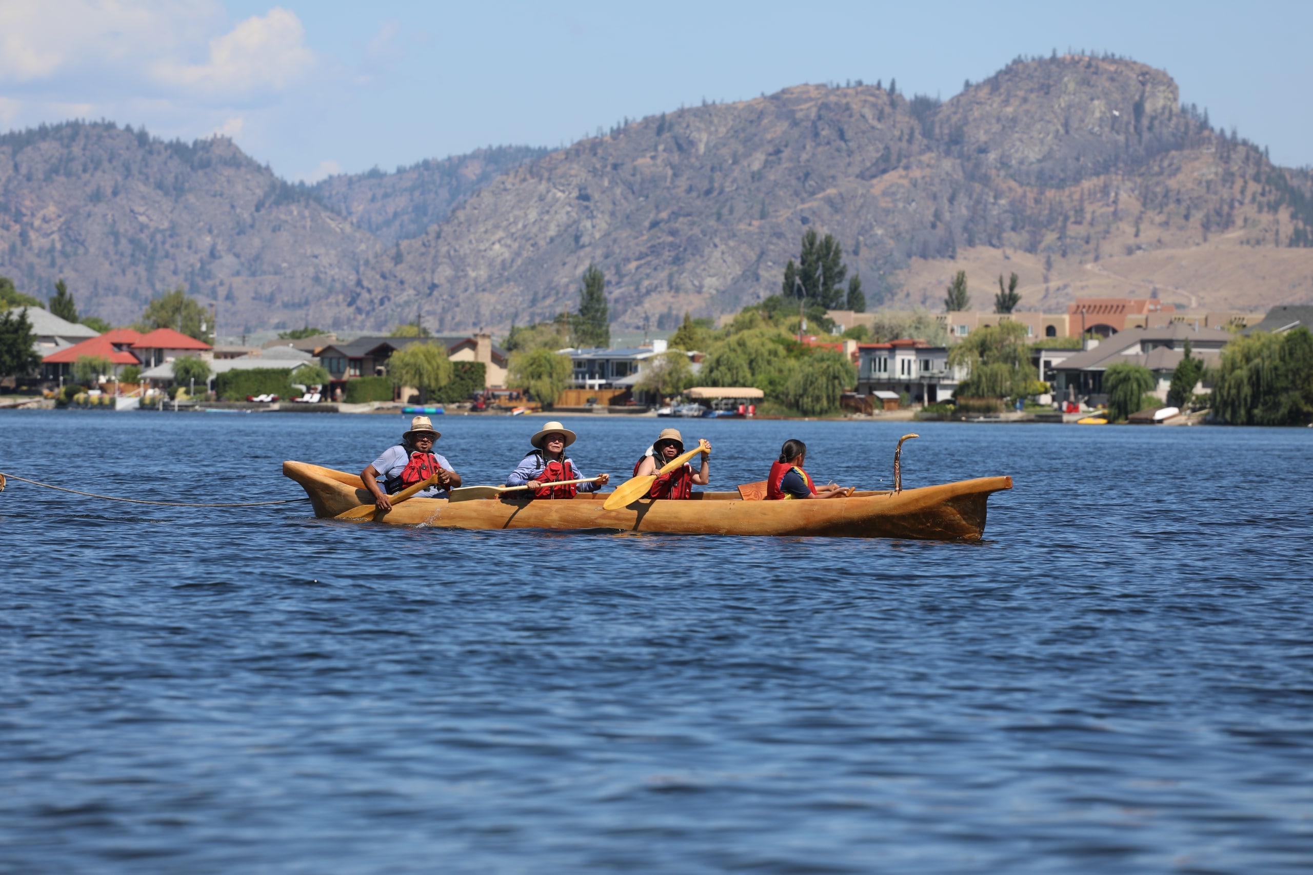 Herman Edward (far left), one of the founders and organizers of the annual Sukʷnaqin July 4th Canoe Journey, paddles with community members on nk’mip (Osoyoos Lake) in sw̓iw̓s (Osoyoos) for the 2024 canoe journey. Photo by Aaron Hemens