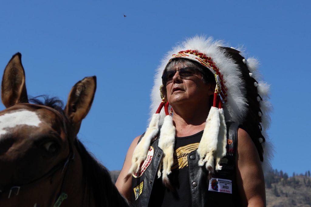 ki law na Clarence Louie, y̓ilmixʷm (Chief) of Osoyoos Indian Band (OIB), prepares to cross into the “U.S.” from “Canada” via horseback at the “Osoyoos-Oroville” border in syilx Okanagan homelands on July 20. Photo by Aaron Hemens