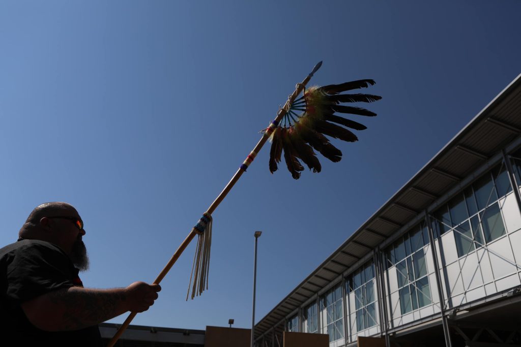 y̓ilmixʷm kalʔlùpaɋʹn Keith Crow holds up a staff at the “Osoyoos-Oroville” border in syilx Okanagan homelands on July 20. Photo by Aaron Hemens