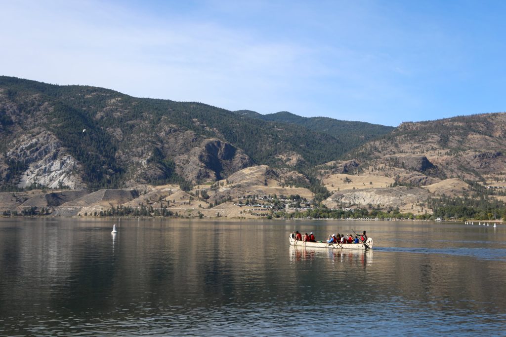 Paddlers in a canoe make their way from Skaha Lake to sx̌ʷəx̌ʷnitkʷ (Okanagan Falls) on Sept. 21, during the syilx Nation’s 2024 salmon feast and celebration weekend. Photo by Aaron Hemens