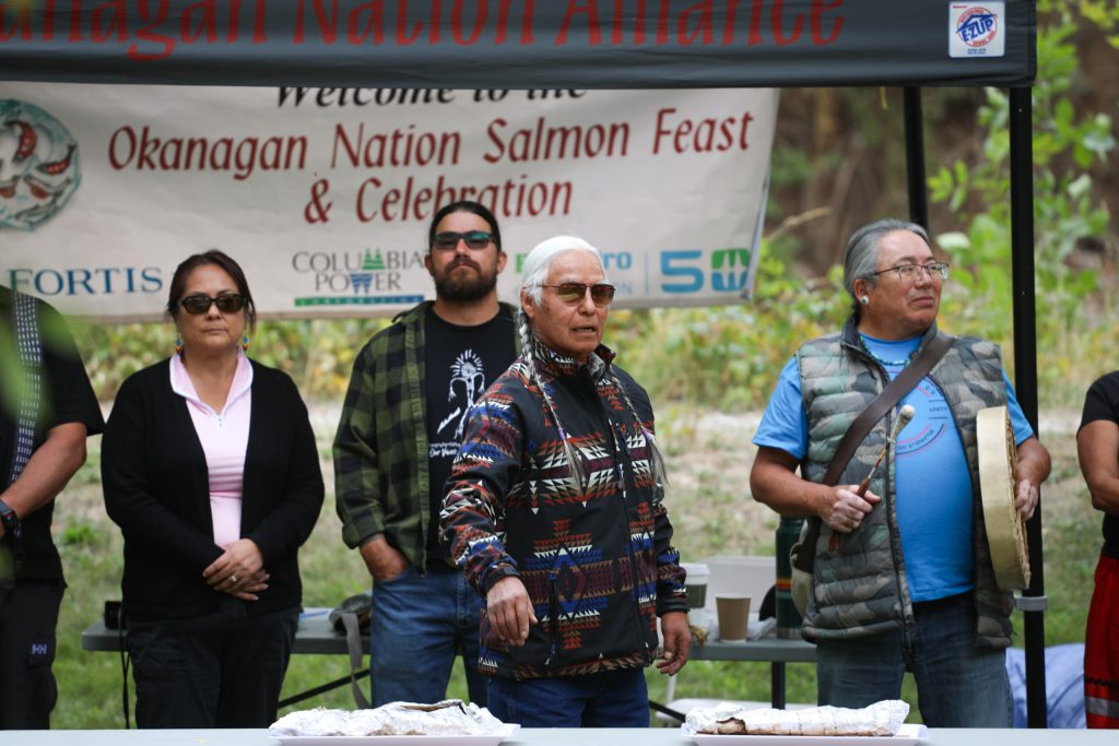 syilx Elder cəqcqalx̌qn Arnie Baptist stands before salmon offerings during the Nation’s 2024 feast and celebration at sx̌ʷəx̌ʷnitkʷ (Okanagan Falls) on Sept. 22. Photo by Aaron Hemens
