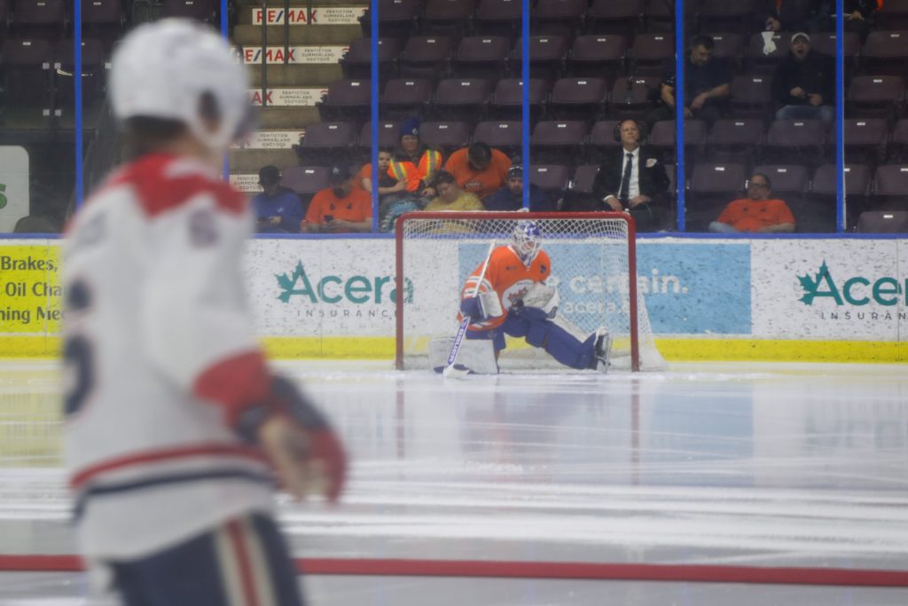 Attendees wearing orange shirts to honour residential school survivors watch as the Penticton Vees and Cowichan Valley Capitals warm up for their game in syilx Okanagan territory on Jan. 31. Photo by Aaron Hemens
