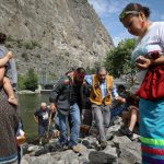 nk’lxwcin (Chad Eneas), left, helps his uncle caylx (Richard Armstrong), following a salmon calling ceremony along the Okanagan River at nʕaylintn (McIntyre Bluff) in syilx territory on June 25. Photo by Aaron Hemens