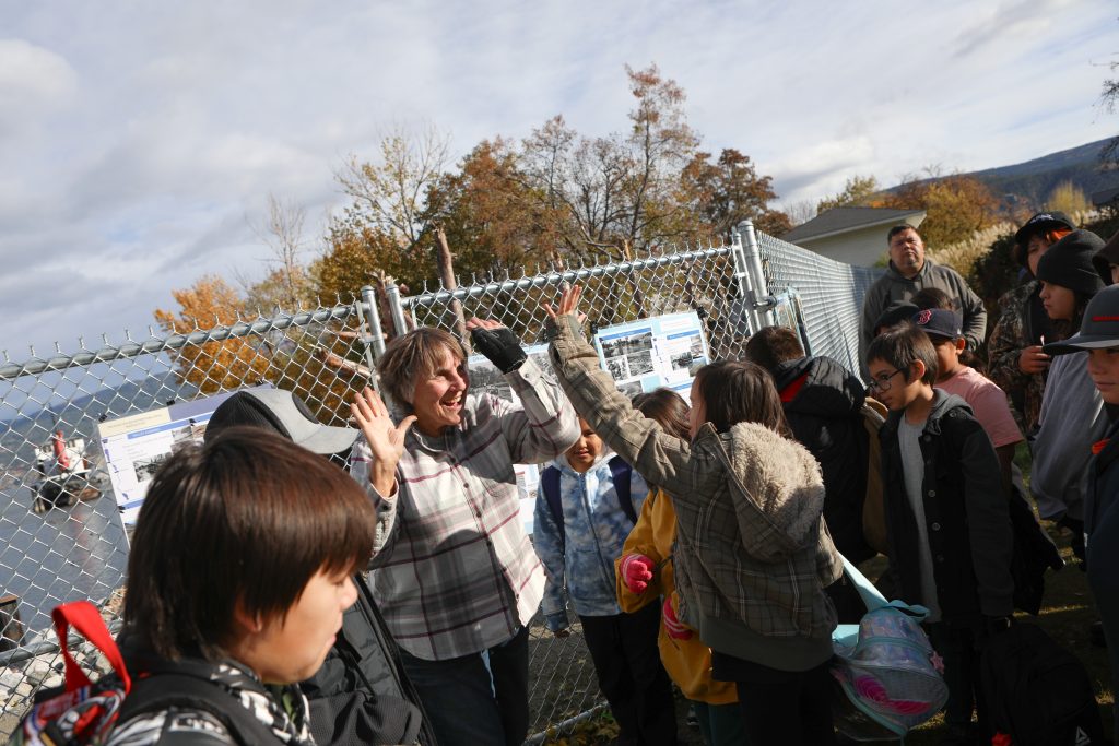 Lee McFadyen, an environmental advocate who helped organize the community planting event with Okanagan Nation Alliance’s (ONA) fisheries team, interacts with elementary students from Outma Sqilx’w Cultural School at the fish passage site at Okanagan Lake Dam in sn’pink’tn (Penticton) on Nov. 7. Photo by Aaron Hemens