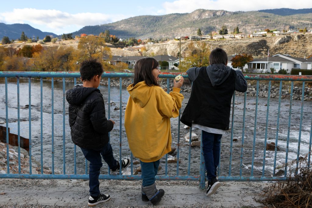 Elementary students from Outma Sqilx’w Cultural School peer down to sq’awsitkʷ (the Okanagan River), from the Okanagan Lake Dam in sn’pink’tn (Penticton) on Nov. 7. Photo by Aaron Hemens