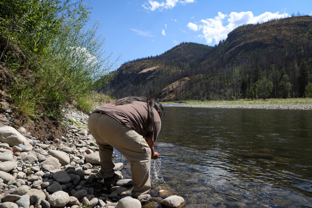 On a hot day on July 16, Joe Gilchrist cools himself with water from the Nicola River, near his sister’s home in Nooatich Indian Band. Photo by Aaron Hemens