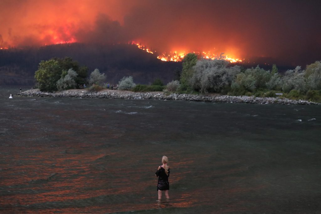 The McDougall Creek wildfire burns in the hills above kɬúsx̌nítkʷ (Okanagan Lake) in syilx Okanagan homelands in August, 2023. Photo by Aaron Hemens