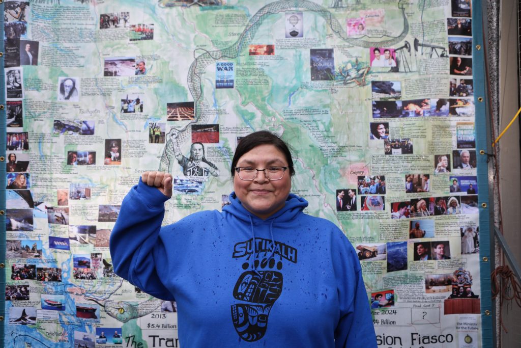 Nlaka’pamux Nation member Red Deer Billie Pierre — who in 2023 was sentenced to 40 days of house arrest over her opposition to the Trans Mountain pipeline expansion — stands in front of an installation by artist George Rammell in ‘Vancouver’ on Feb. 7. Photo by Aaron Hemens