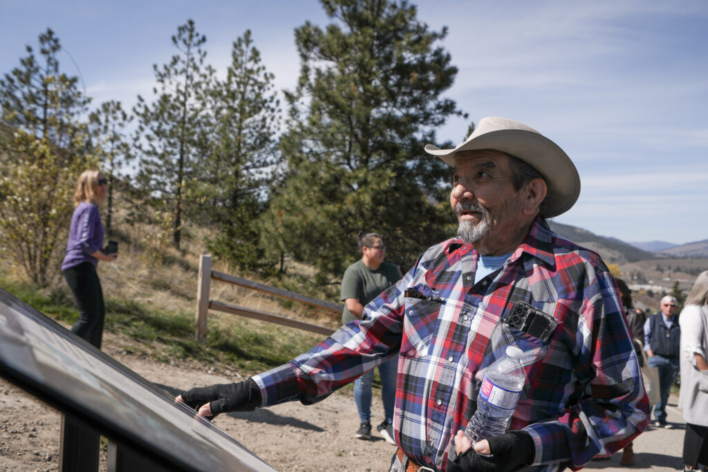 caylx (Richard Armstrong), a syilx Elder and knowledge keeper, looks up towards ackɬt’pus (Giant’s Head Mountain) after examining one of four new interpretive signs on April 10. The signs detail syilx history and culture along the trails of the mountain. Photo by Aaron Hemens