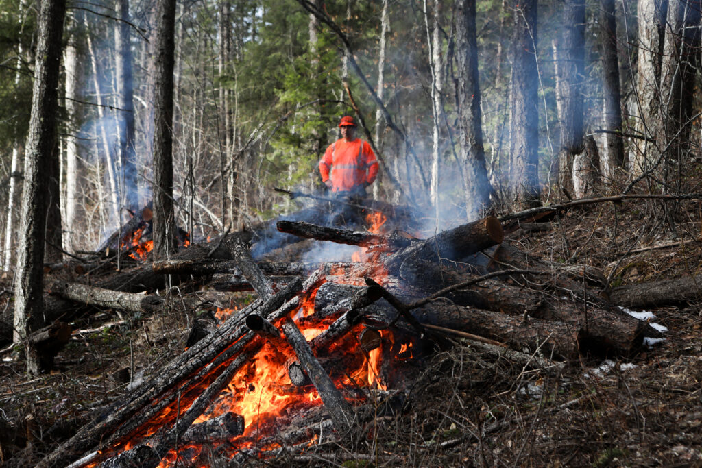 syilx Nation Member Charles Kruger, a technician with Ntityix Resources, monitors a controlled burn in Westbank First Nation, in syilx territories, last year. Photo by Aaron Hemens