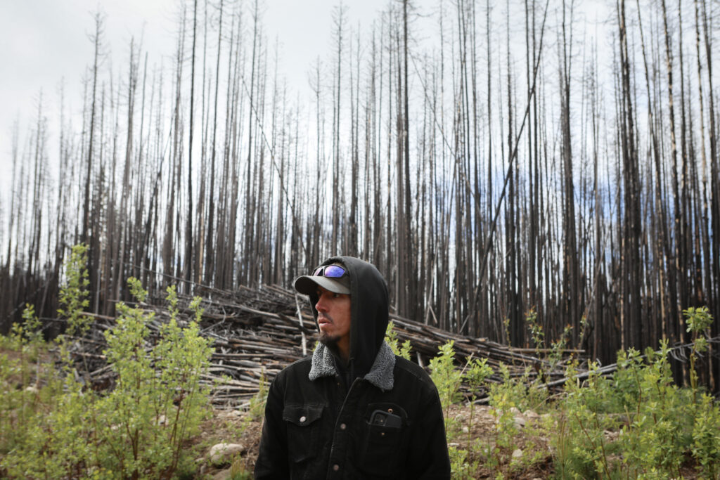 Vernon Louie, an Osoyoos Indian Band member and grounds operation manager with Nk’Mip Forestry, stands in forested area on June 10, 2026, which is one of the sites of a future wildfire restoration project. The area was impacted by the 2021 Nk'Mip Wildfire. Photo by Aaron Hemens