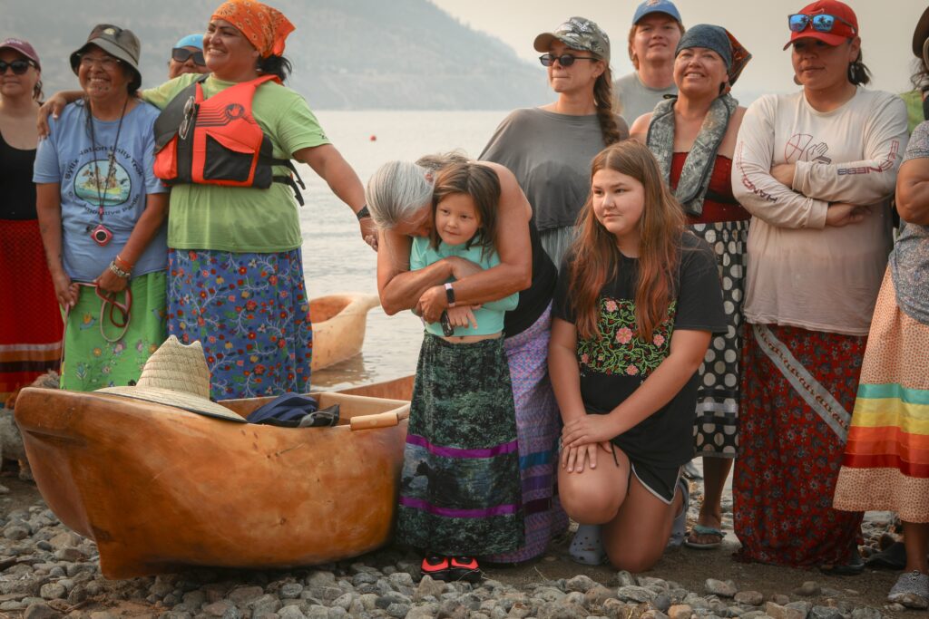Paddlers with the syilx Nation’s 2026 Unity Trek Commemorative Paddle pose for a picture together on July 30 after arriving in Penticton, following six-days of paddling on Okanagan Lake. The canoes were carved by Herman Edward, who participated in the original journey in 2001. Photo by Aaron Hemens
