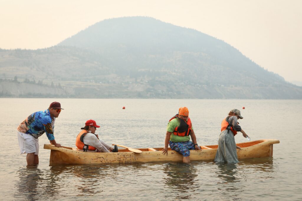 Community members exit a canoe after arriving in Penticton on July 30. The canoe was carved by Herman Edward, who participated in the original journey in 2001. Photo by Aaron Hemens